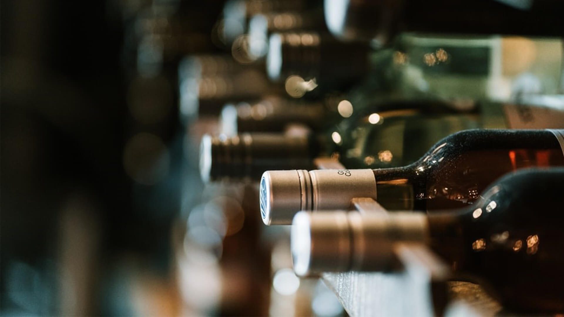 Dusty wine bottles laying in storage in a row